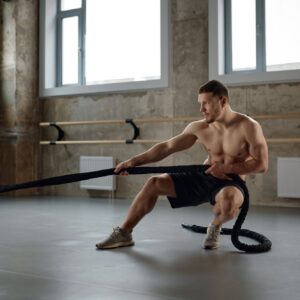 A strong man pulling training sports rope front view