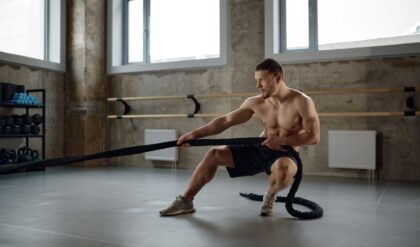 A strong man pulling training sports rope front view